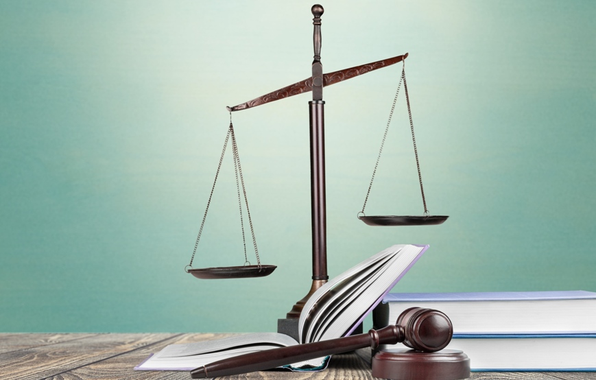 balanza de la justicia junto a un mazo de juez