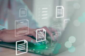 Hands working on a computer with documents